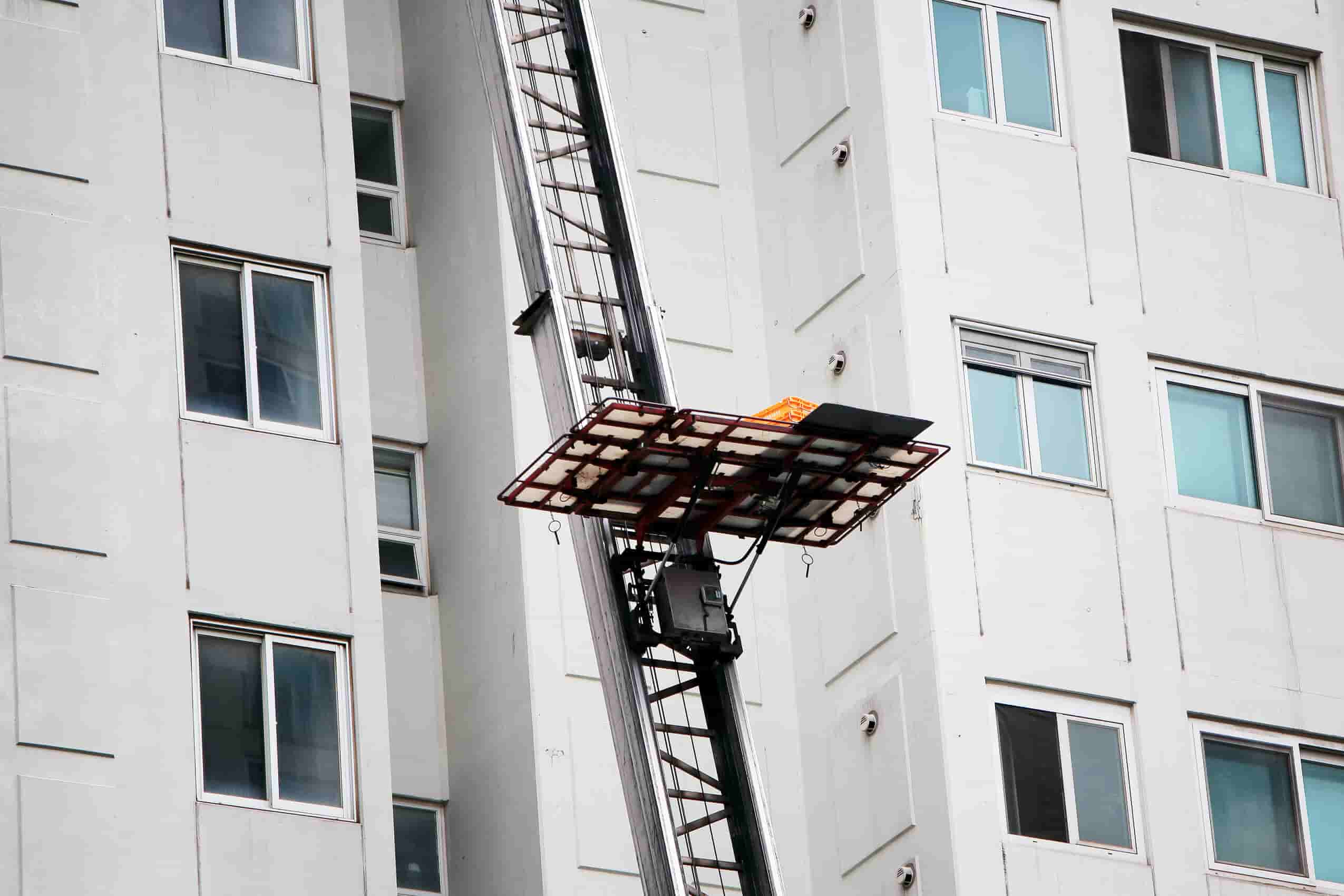 Kırmızı asansörle yoğun sokakta eşya nakli